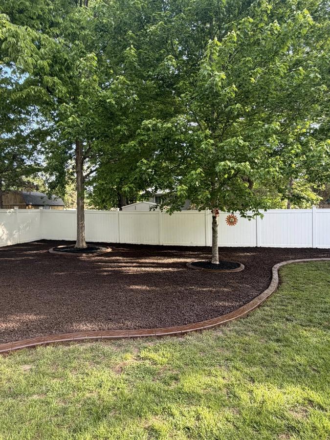 Curved decorative concrete border framing a large mulch bed.