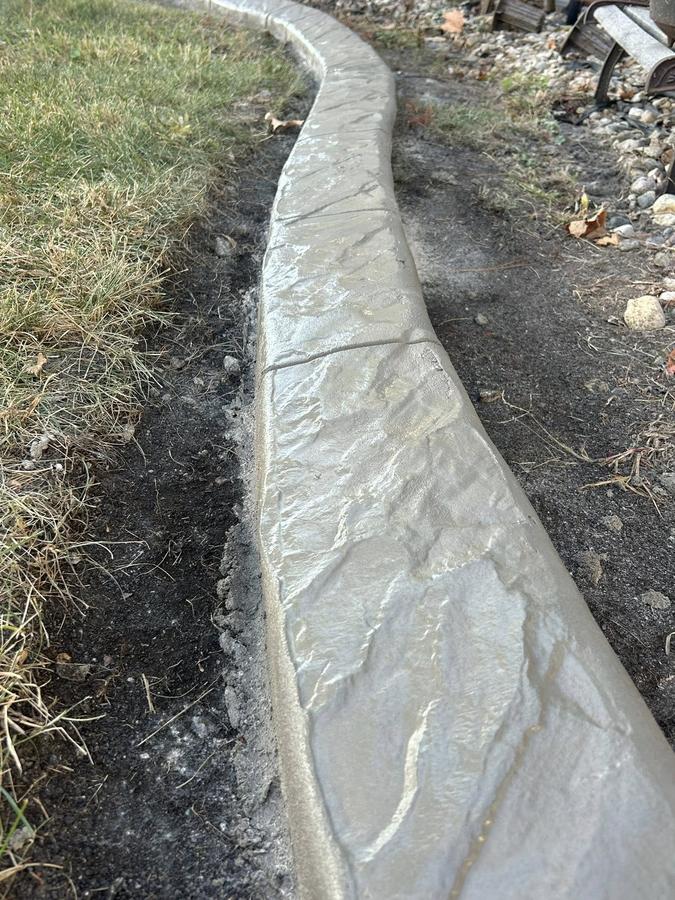 Wide decorative concrete border with textured finish during installation.